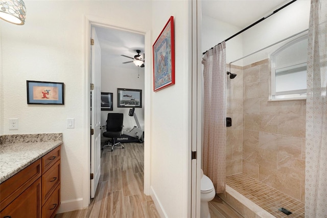 bathroom with walk in shower, toilet, vanity, and ceiling fan