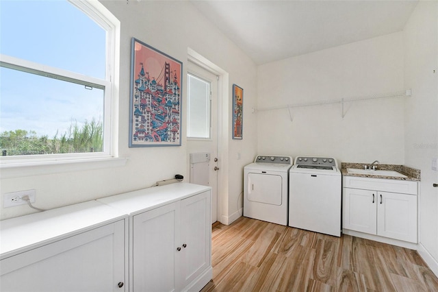 washroom featuring cabinets, independent washer and dryer, sink, and light wood-type flooring