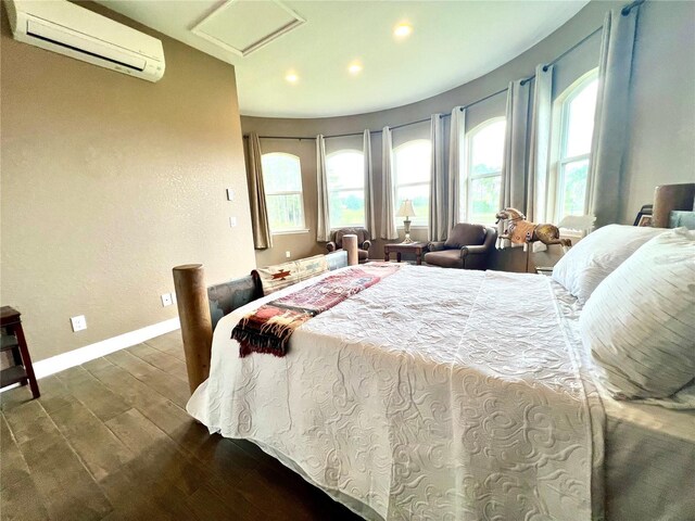 bedroom with an AC wall unit and hardwood / wood-style floors