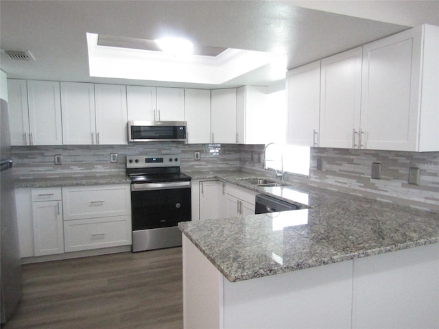 kitchen featuring kitchen peninsula, sink, white cabinets, and stainless steel appliances