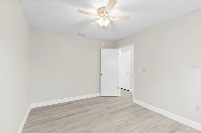 unfurnished room featuring ceiling fan, light hardwood / wood-style floors, and a textured ceiling