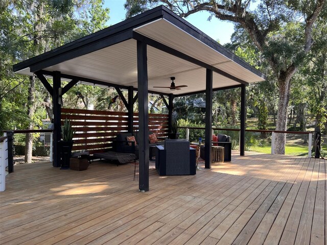 wooden deck with a gazebo, an outdoor hangout area, and ceiling fan