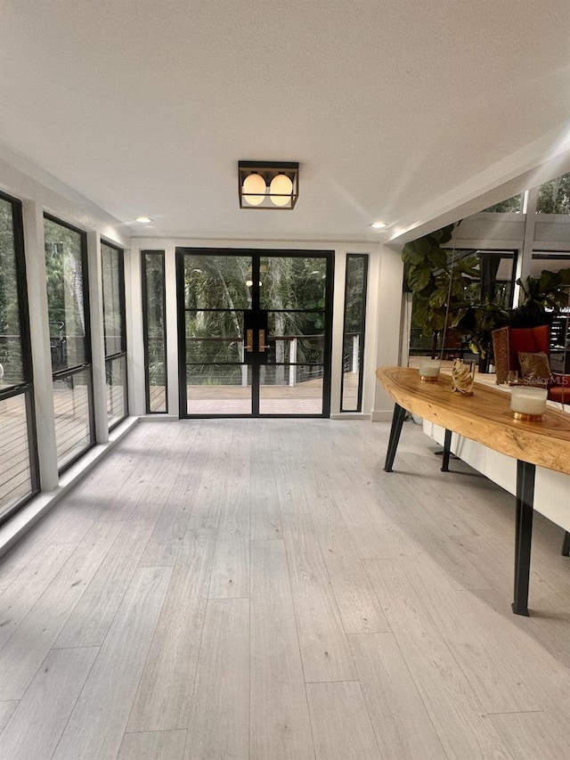 unfurnished dining area with light hardwood / wood-style flooring and a wall of windows