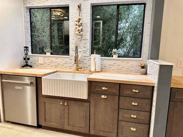 bar featuring wood counters, dark brown cabinetry, sink, tasteful backsplash, and stainless steel dishwasher