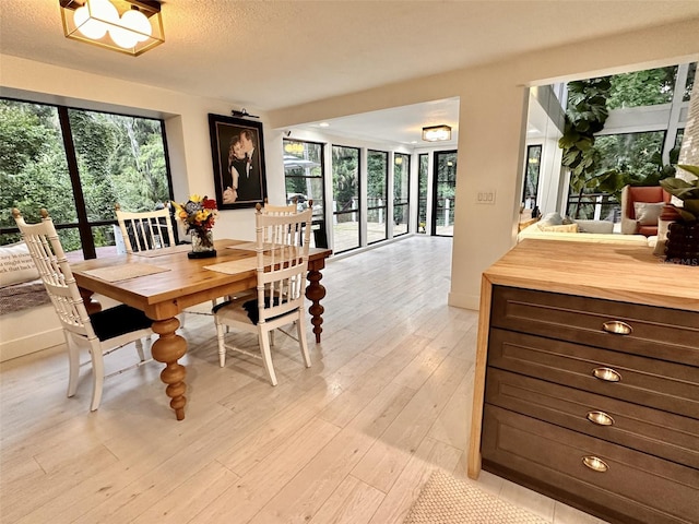 dining area featuring a textured ceiling and light wood-type flooring