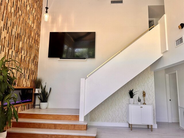 stairs featuring hardwood / wood-style flooring and a towering ceiling