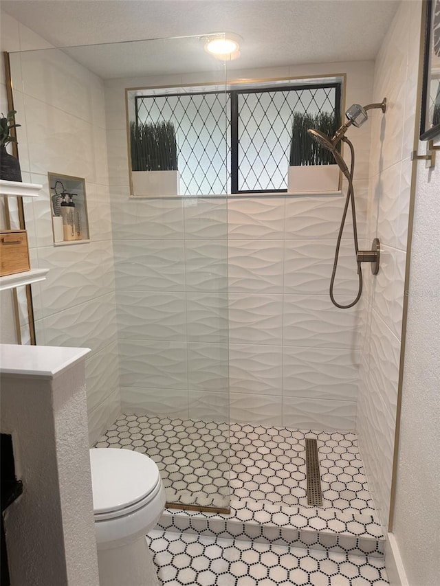 bathroom featuring a tile shower and toilet