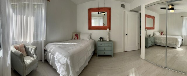 bedroom with ceiling fan, a closet, and light hardwood / wood-style flooring