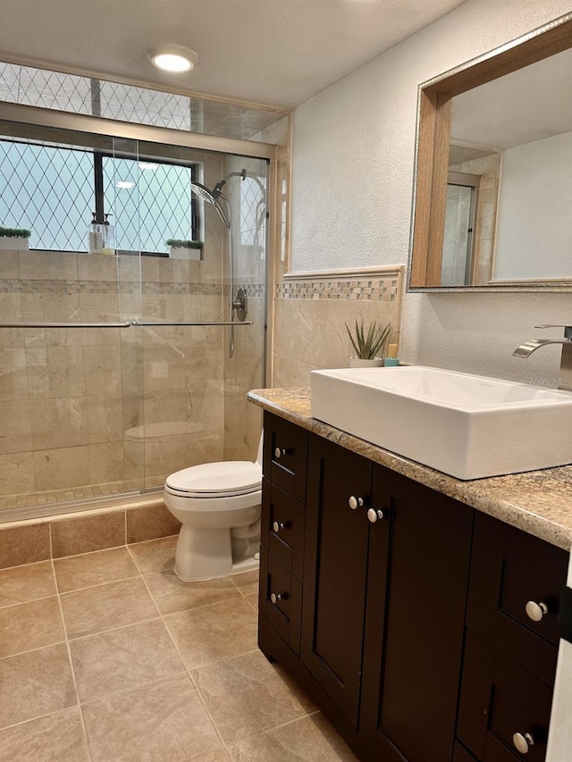 bathroom featuring vanity, toilet, and a shower with door