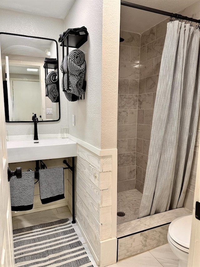 bathroom featuring a shower with curtain, toilet, and sink