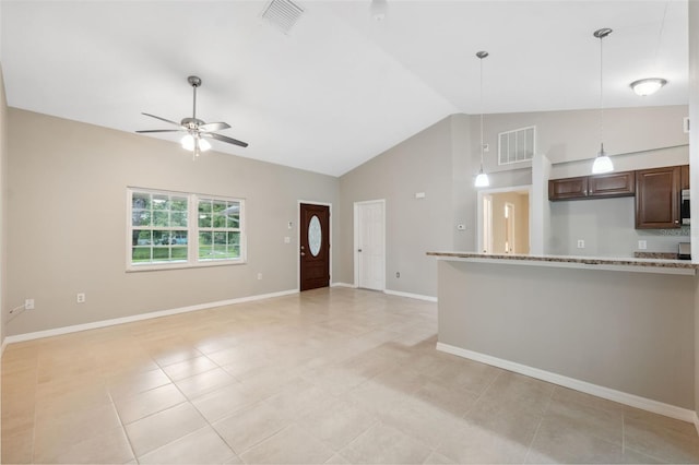 unfurnished living room with ceiling fan, high vaulted ceiling, and light tile patterned floors