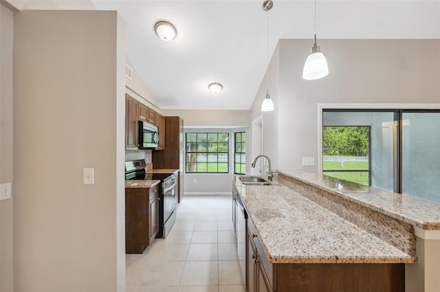 kitchen featuring light tile patterned flooring, decorative light fixtures, sink, stainless steel appliances, and light stone countertops