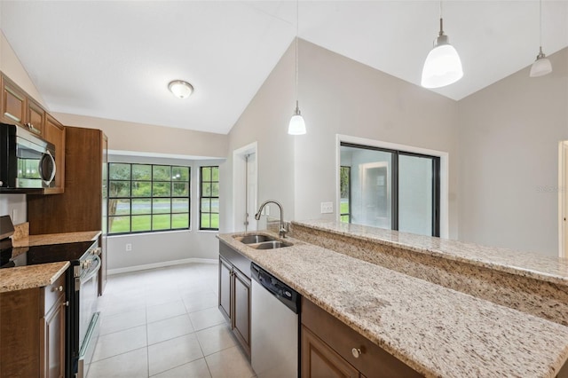 kitchen featuring sink, hanging light fixtures, a center island with sink, stainless steel appliances, and light stone countertops