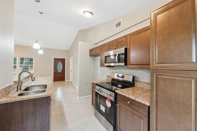 kitchen with lofted ceiling, sink, pendant lighting, stainless steel appliances, and light stone countertops