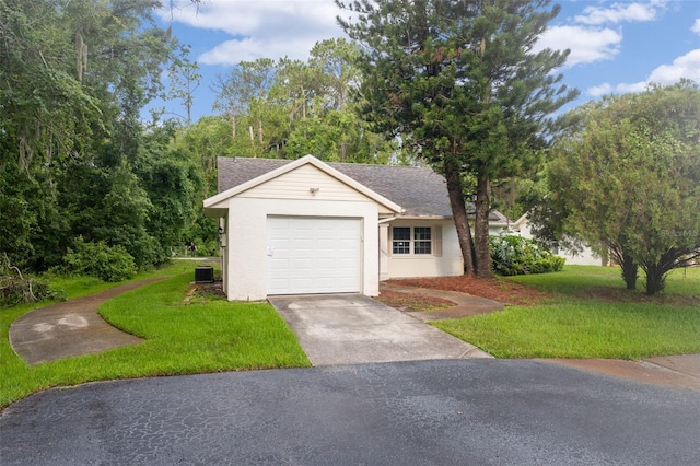 view of front facade with cooling unit, a garage, and a front lawn