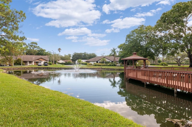 view of dock with a yard, a gazebo, and a water view