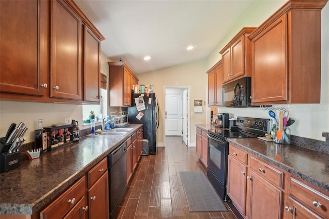 kitchen with sink, black appliances, and lofted ceiling