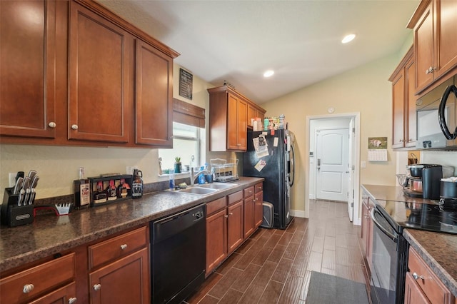 kitchen featuring dark stone counters, sink, black appliances, and vaulted ceiling