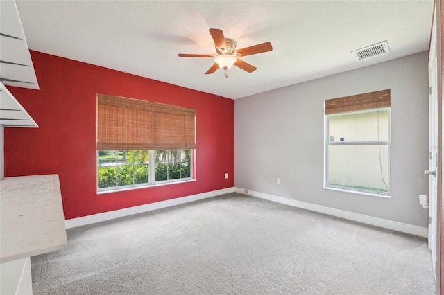 empty room featuring ceiling fan and carpet