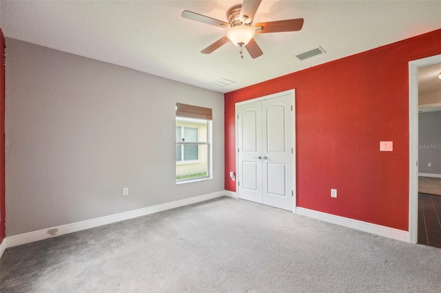 unfurnished bedroom featuring carpet, a closet, and ceiling fan