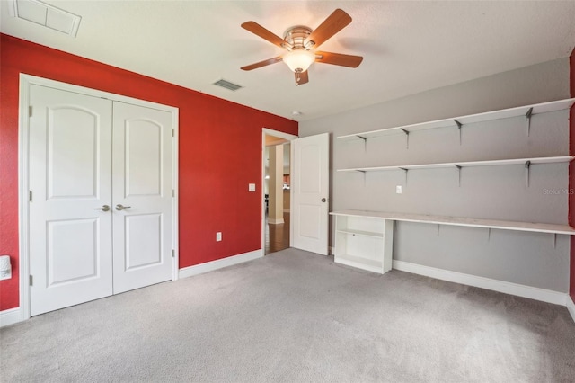 interior space with ceiling fan, light carpet, and a closet