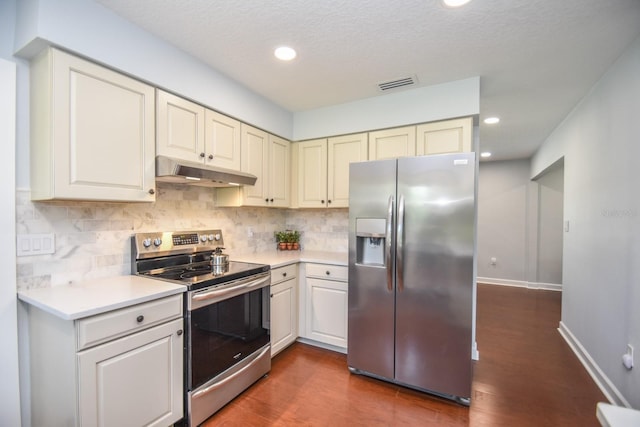 kitchen featuring dark wood-type flooring, a textured ceiling, decorative backsplash, and stainless steel appliances