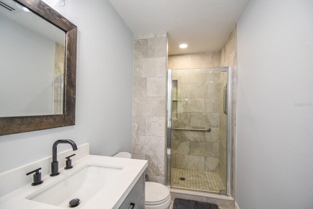 bathroom with a textured ceiling, toilet, vanity, and an enclosed shower