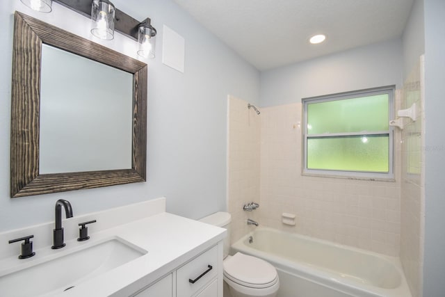 full bathroom with vanity, tiled shower / bath, and toilet