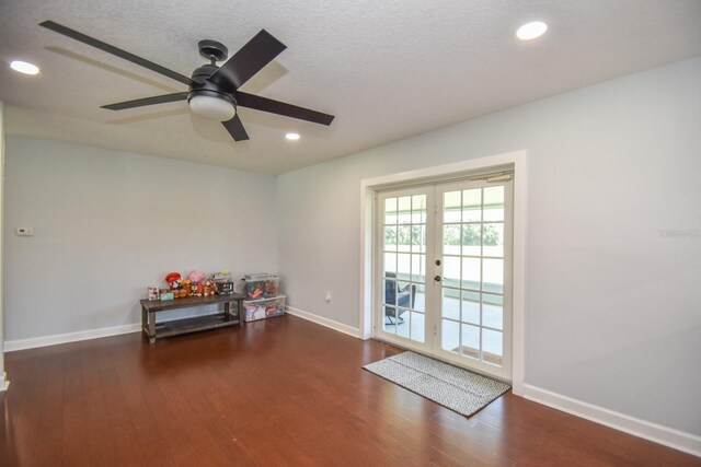 misc room featuring dark wood-type flooring, a textured ceiling, french doors, and ceiling fan