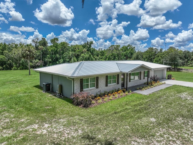 single story home featuring central AC unit, a garage, and a front yard