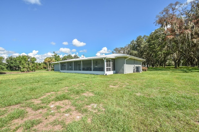 back of property with a sunroom and a lawn