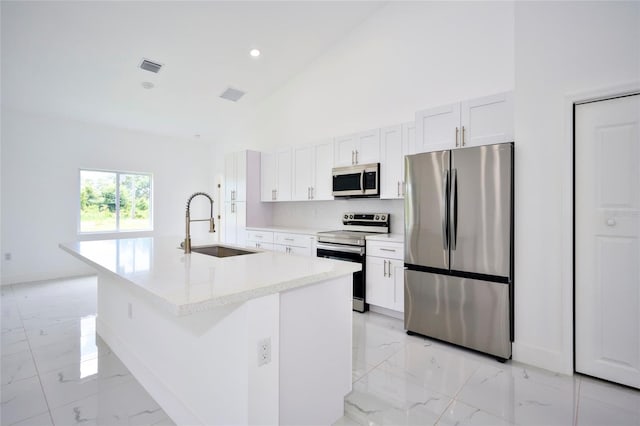 kitchen featuring a sink, appliances with stainless steel finishes, an island with sink, high vaulted ceiling, and marble finish floor