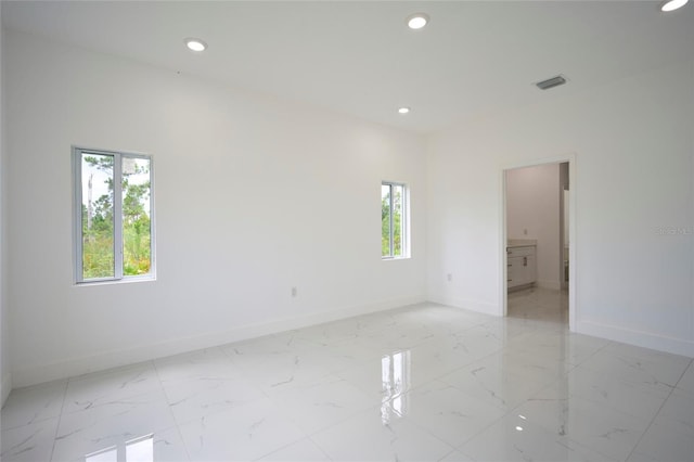 empty room featuring recessed lighting, visible vents, marble finish floor, and baseboards