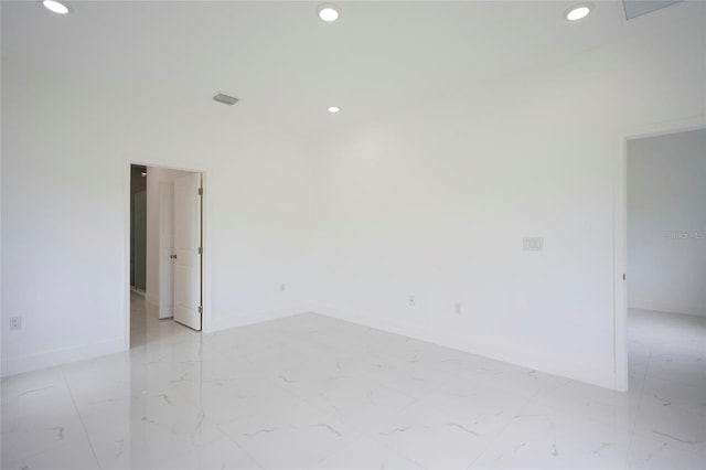 spare room with baseboards, recessed lighting, and marble finish floor