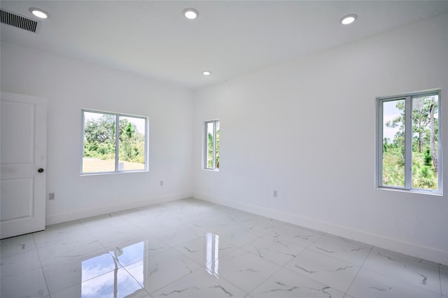 empty room with visible vents, baseboards, recessed lighting, and marble finish floor