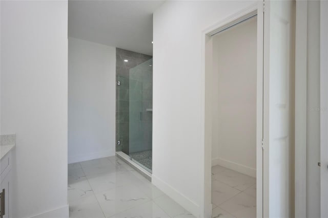 bathroom featuring a shower stall, marble finish floor, baseboards, and vanity
