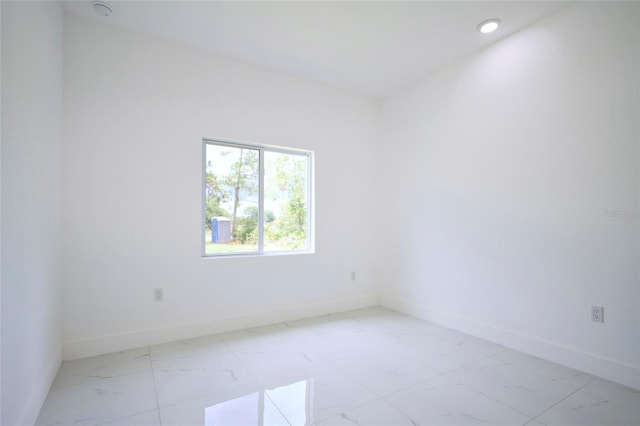 unfurnished room featuring recessed lighting, marble finish floor, and baseboards