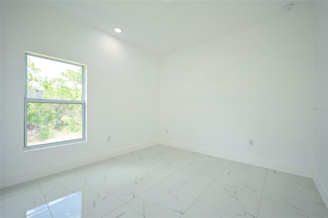 spare room featuring marble finish floor, baseboards, and recessed lighting