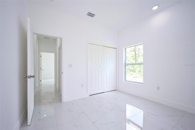 unfurnished bedroom with a closet, visible vents, recessed lighting, marble finish floor, and baseboards