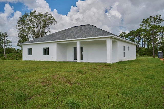 rear view of property featuring a lawn