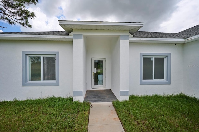 view of exterior entry featuring a yard