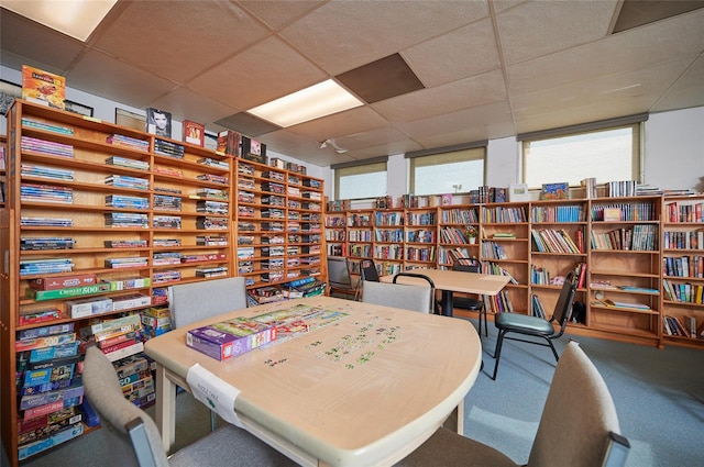 carpeted dining area with a drop ceiling