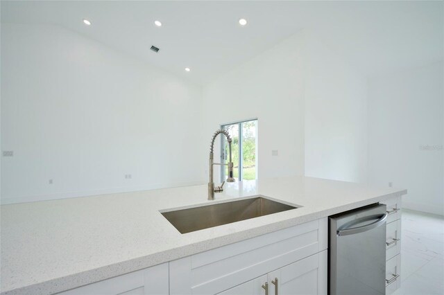 kitchen with light stone countertops, visible vents, recessed lighting, marble finish floor, and a sink