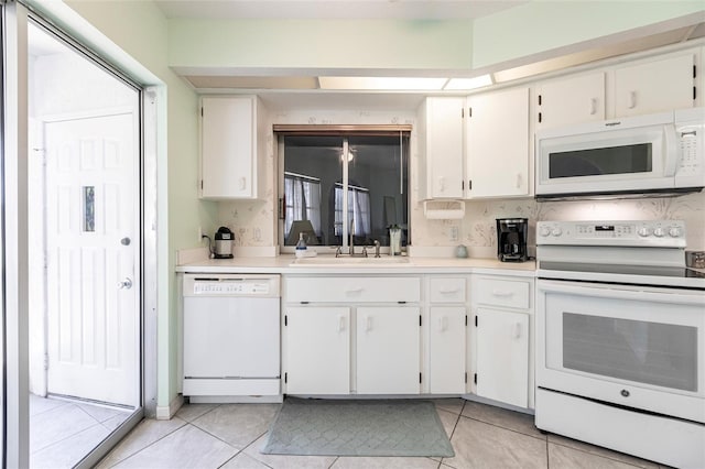 kitchen with white appliances, white cabinets, sink, and light tile flooring