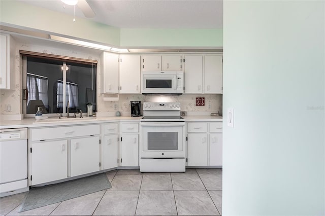 kitchen featuring ceiling fan, white appliances, backsplash, light tile floors, and white cabinetry