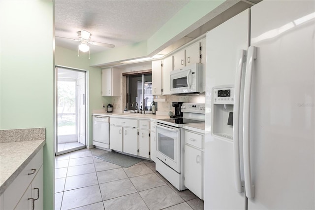 kitchen featuring ceiling fan, white appliances, light tile flooring, a textured ceiling, and white cabinets