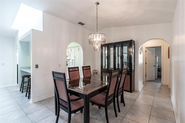 dining space with a chandelier, light tile floors, and lofted ceiling