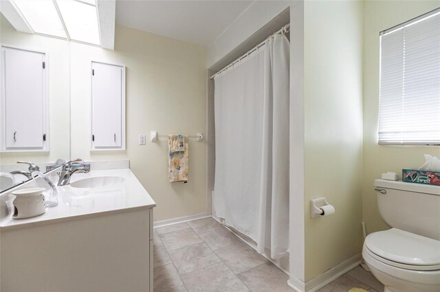 bathroom with tile flooring, large vanity, and toilet