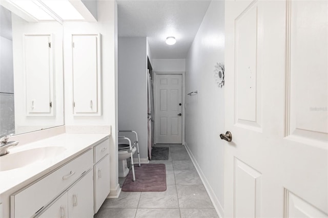 bathroom featuring tile floors, vanity, and toilet