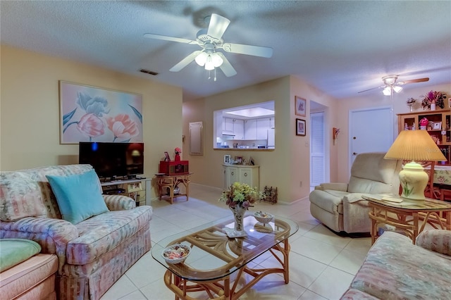 tiled living room with a textured ceiling and ceiling fan